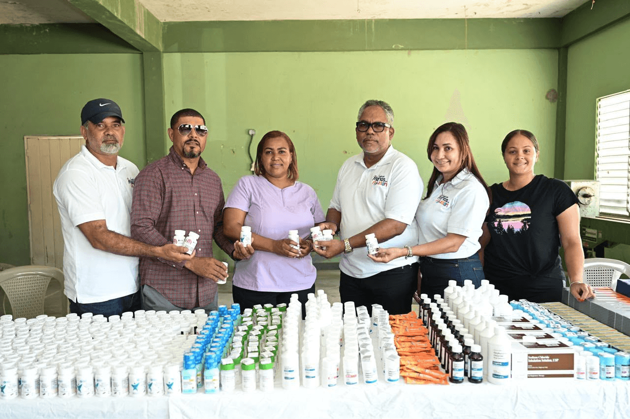 Equipo de la fundación detrás de una mesa larga cubierta de medicamentos
