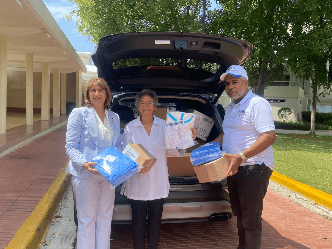 Voluntarios cargando cajas de insumos médicos en un vehículo
