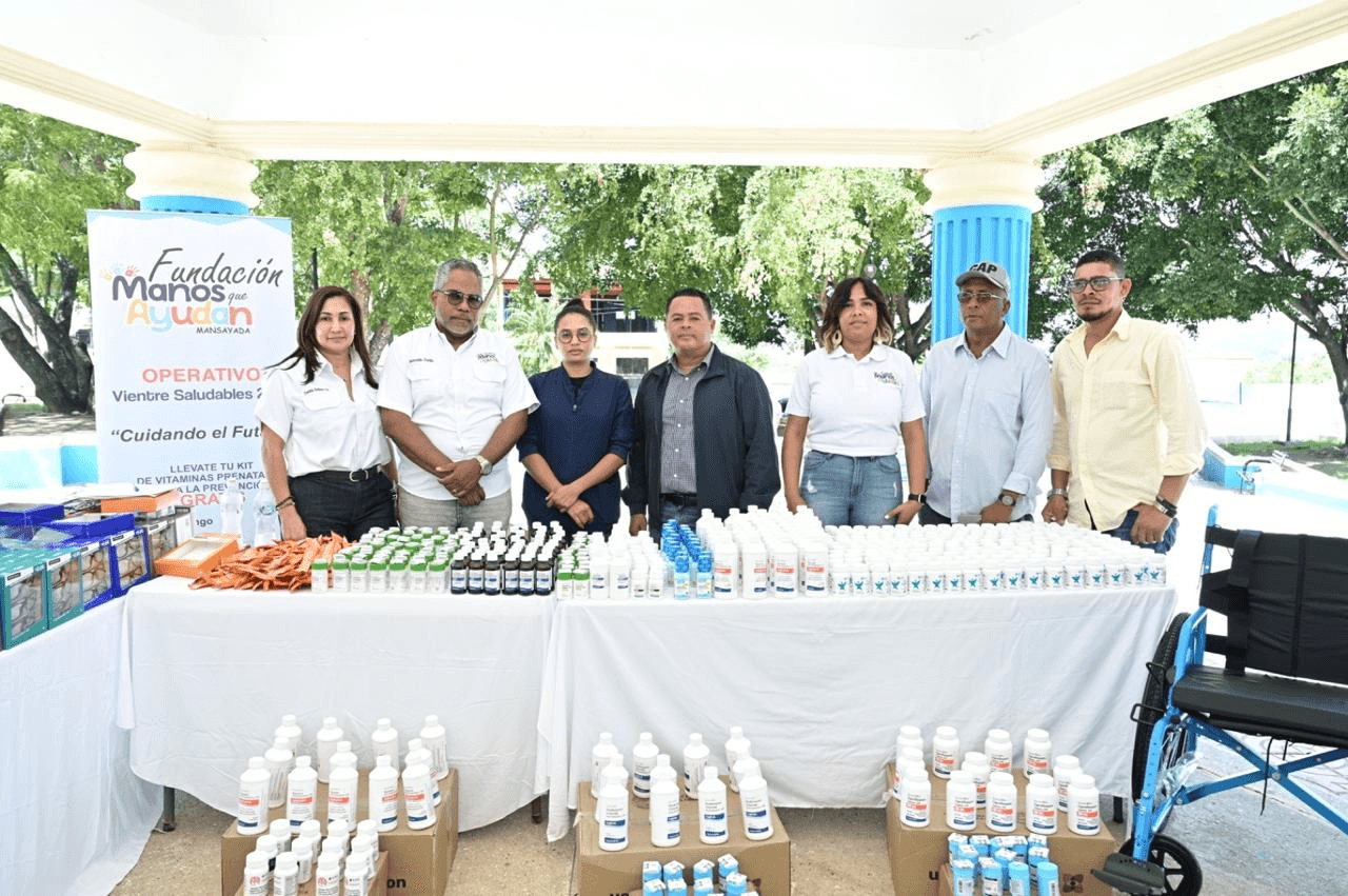 Equipo de la fundación y colaboradores junto a las mesas de medicamentos y silla de ruedas